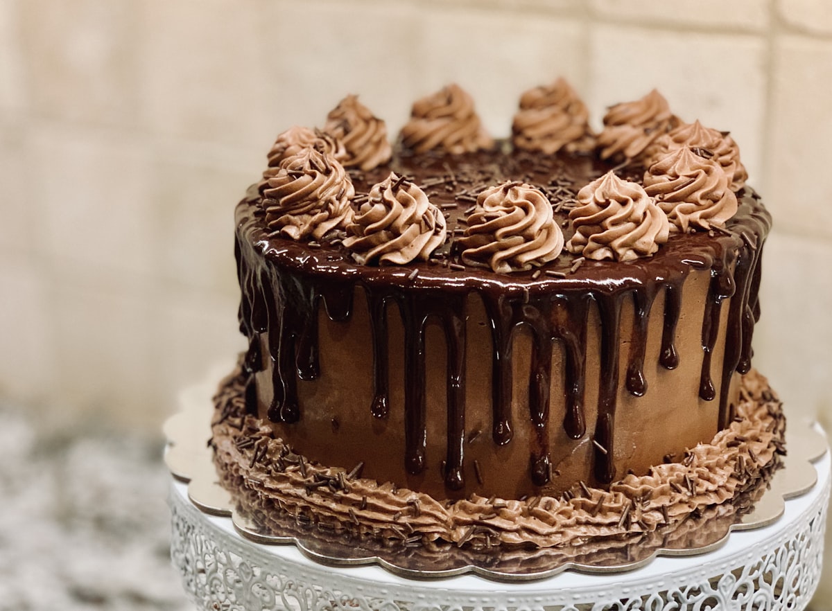 Layered celebration cake with chocolate drip and toppings